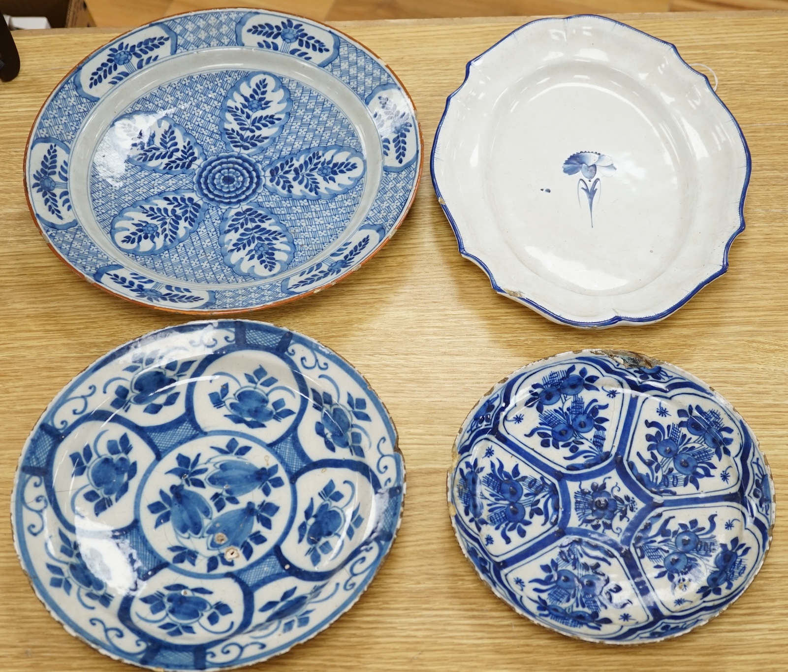 Four various continental delftware dishes, 18th and 19th century, largest 31cm diameter. Condition - various cracks and chipping to edges